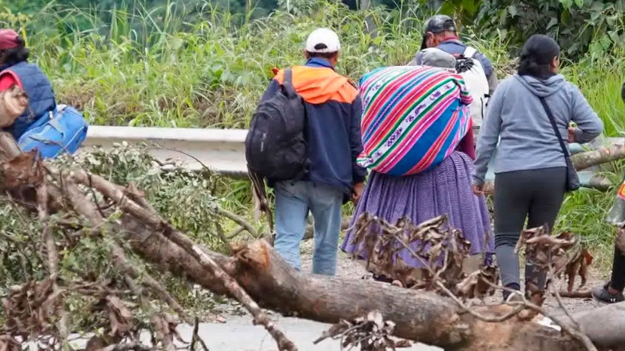 Viajeros caminan con equipaje por bloqueos en la ruta a Caranavi